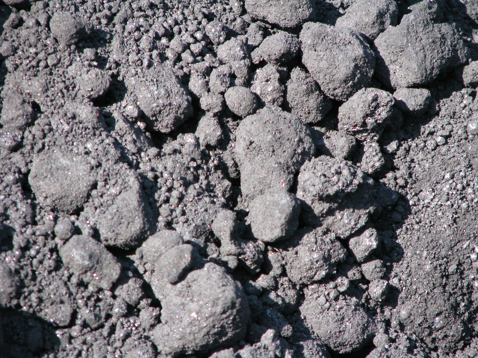 Close-up of petroleum coke showing its porous carbon texture